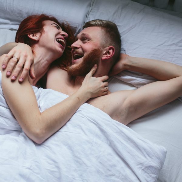 Um casal deitado e abraçado na cama